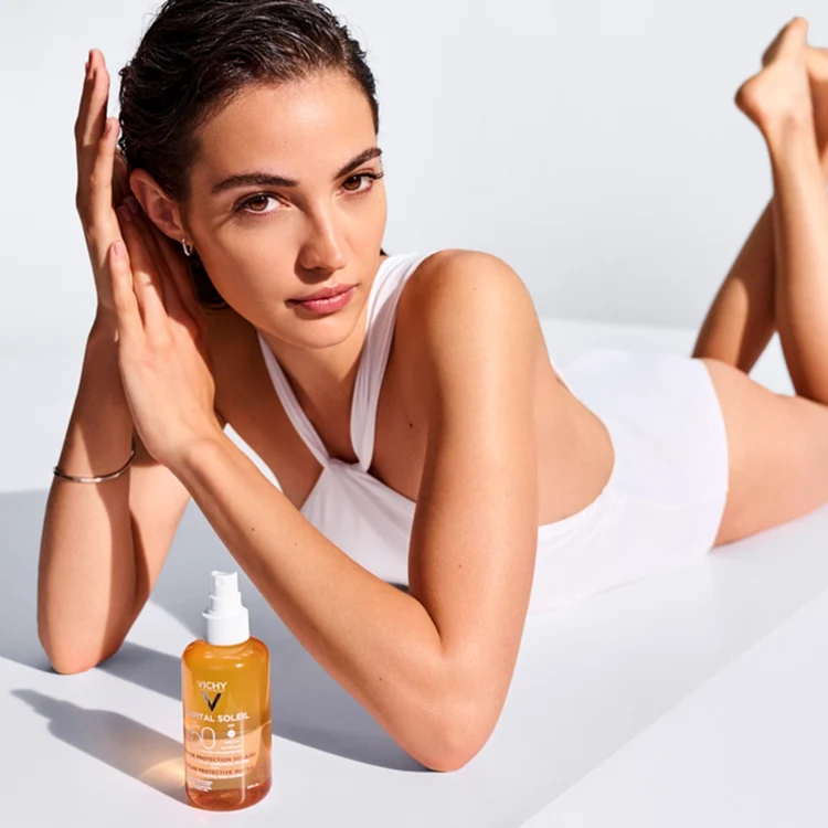 Femeie lângă apă cu protecție solară pentru bronz sporit Vichy Capital Soleil SPF50+ Foto Medimfarm 