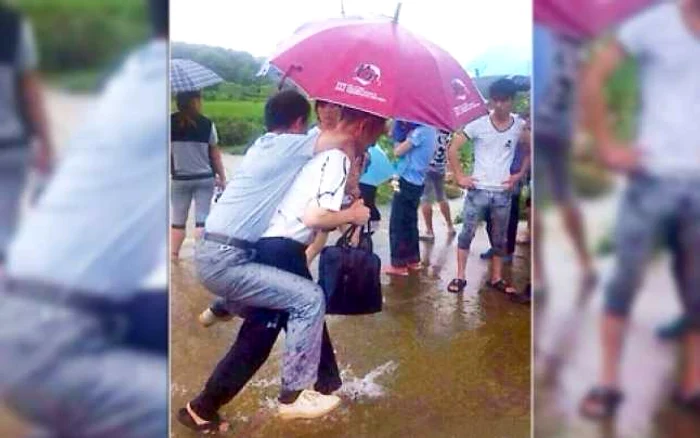 Imaginea cu oficialul cărat în spate, deşi apa nu era foarte înaltă, a devenit virală. FOTO via Weibo