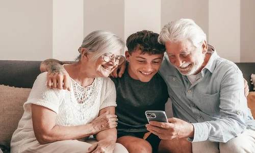 Nepotul si bunicii stand pe canapea uitandu se la telefon 2489776393 jpg