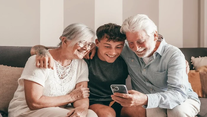 Nepotul si bunicii stand pe canapea uitandu se la telefon 2489776393 jpg