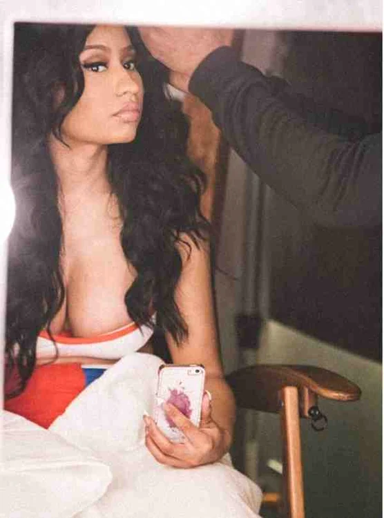 Nicki Minaj îşi face de lucru cu telefonul în timp ce stilistul o aranjează pentru ieşirea în public