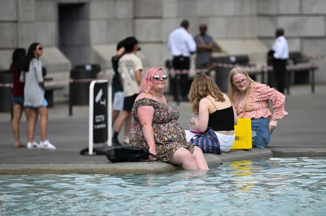 Caniculă în Marea Britanie - O femeie se răcoreşte într-o fântână arteziană din Londra FOTO Profimedia
