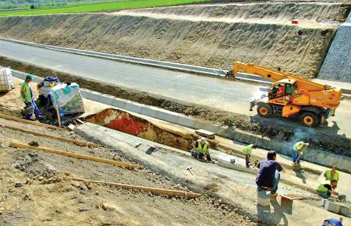 Muncitorii lucrează  la terasamentul  autostrăzii