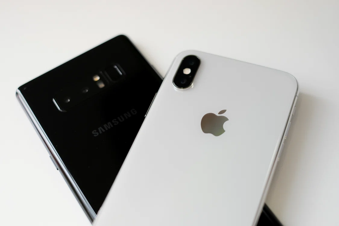 foto telefon mobil iPhone așezat peste un telefon Samsung