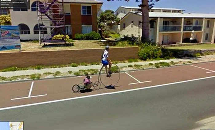 Un om îşi plimbă maimuţica cu o bicicletă ruptă din filmele lui Charlie Chaplin