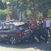 protestatarii din Piata Victoriei incercand sa rastoarne o masina a jandarmeriei png