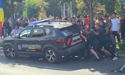 protestatarii din Piata Victoriei incercand sa rastoarne o masina a jandarmeriei png