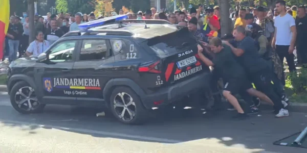 protestatarii din Piata Victoriei incercand sa rastoarne o masina a jandarmeriei png
