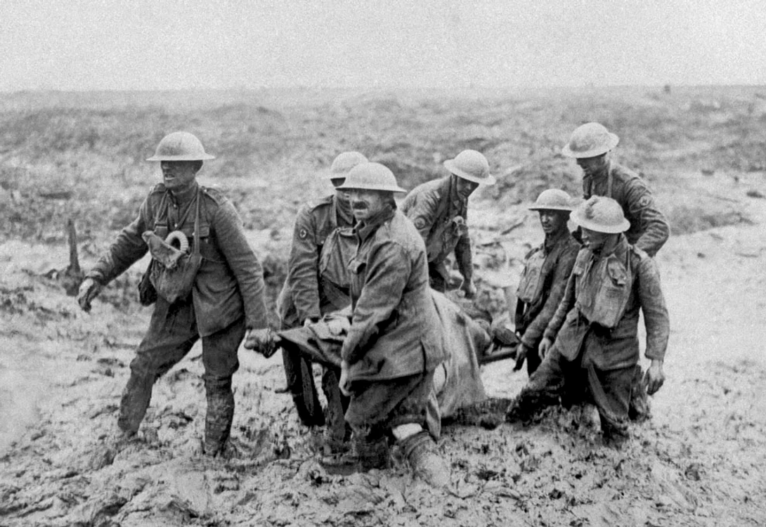 O patrulă cu un rănit pe o targă îşi croieşte cu greu drum prin noroiul care ajunge până la genunchi,  în Bol Singhe,  în timpul avansului britanic în Flandra,  20 august 1917.
