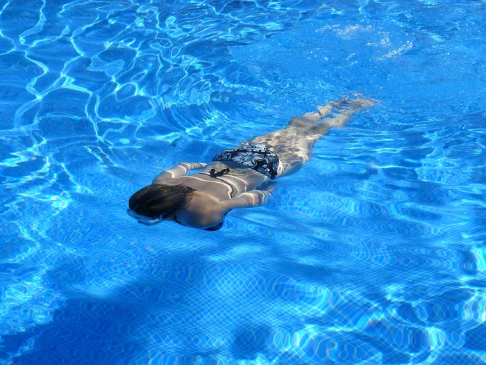 Fată care înoată într-o piscină