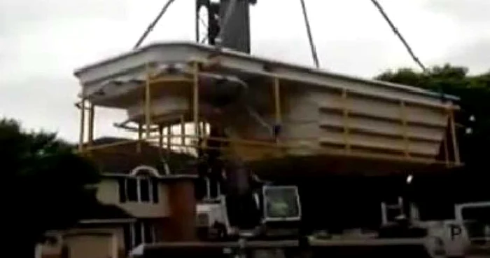 O macara ce transporta o piscină s-a prăbuşit peste o casă