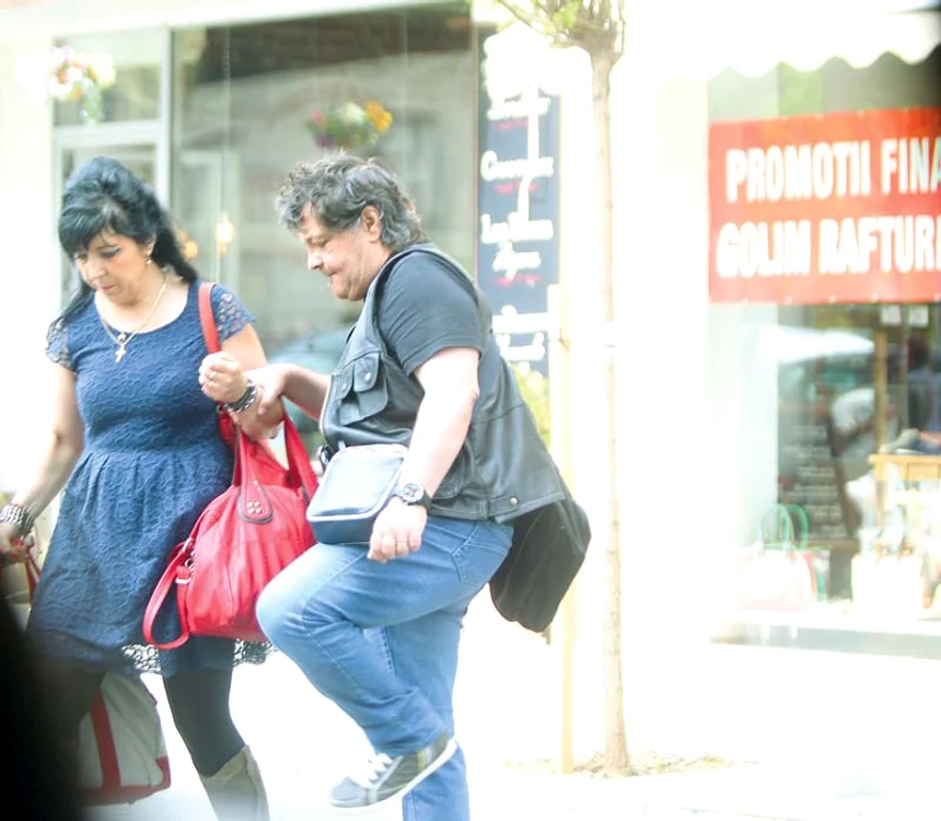
    Leo se sprijină de  Florenţa pentru a putea  trece strada. Ea nu  l-a lăsat să care nici  măcar un bagaj  