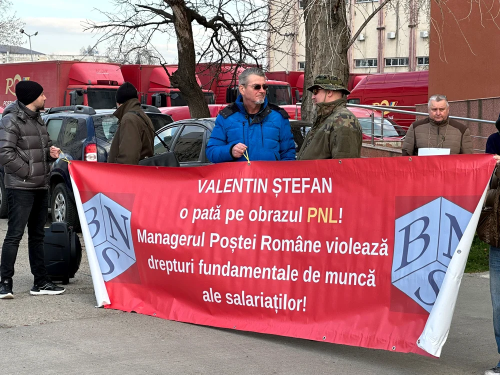 Poștași care țin un banner în mâini la protest