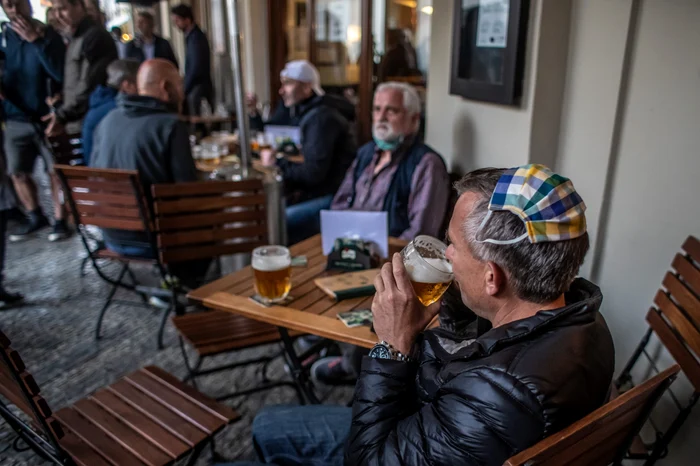 
    Praghezii au ieșit la o bere și masca îi încurcă așa că și-au ”montat-o” pe cap foto: EPA-EFE  