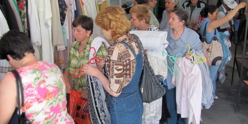 Oamenii stau la coadă pentru a putea cumpăra hainele la mâna a doua 