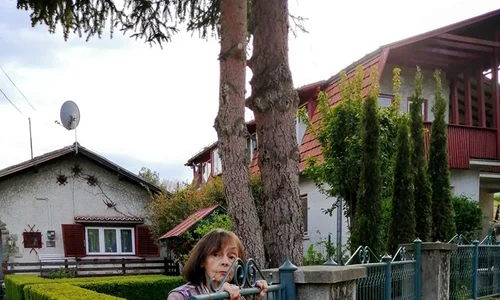 Marina Voica, lipită de gard, așteptând să schimbe o vorbă cu cineva jpeg