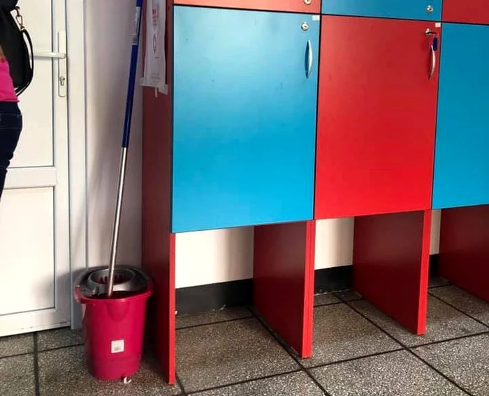 Mopul și găleata cu apă murdară uitate pe hol