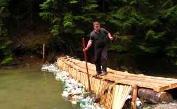 Cristian Dragotă strânge pet-urile prinse în grebla ecologică, invenţia sa (foto: Claudiu Iuşan, biologul PNMR)