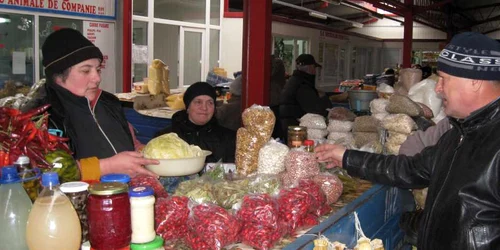 Adriana Munteanu (stânga), o vânzătoare din comuna Măgura, vinde cu 5 lei kilogramul de varză murată