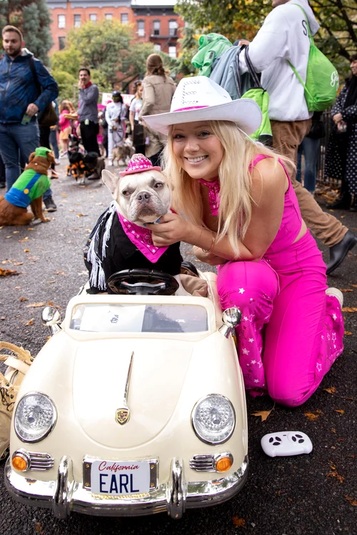 Un cățel și stăpâna lui, costumați în Barbie și Ken de Halloween. New York, octombrie 2023