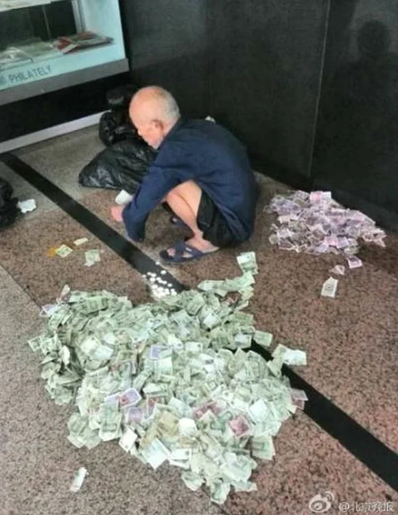 
    Bătrânul numără fiecare monedă şi hârtie în parte înainte de depunereFoto The Beijing News  
