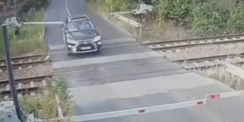 Momentul în care un şofer rupe bariera de la trecerea peste calea ferată din Brăneşti. Foto