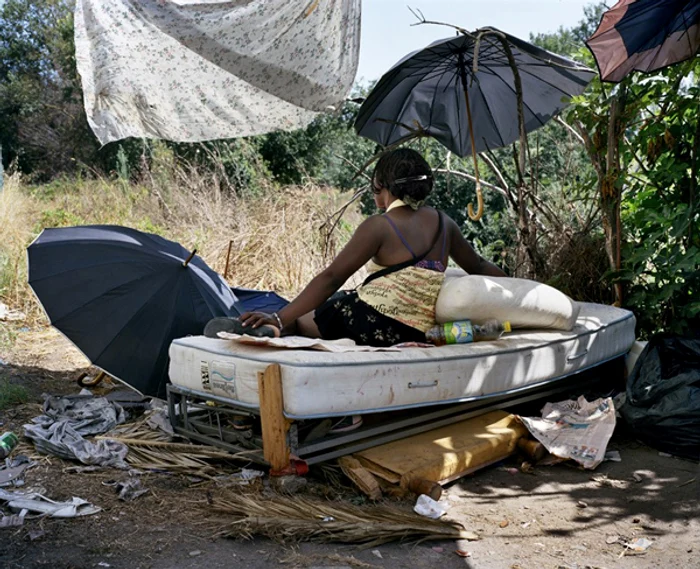 
    Prostituată din Nigeria pe saltea, în mijlocul campului  