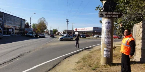 Ştefan Văduva, reprezentantul firmei ce execută lucrările pe strada Oituz, arătând spre indicatoarele rutiere acoperite care, de luni dimineaţă, vor deveni literă de lege