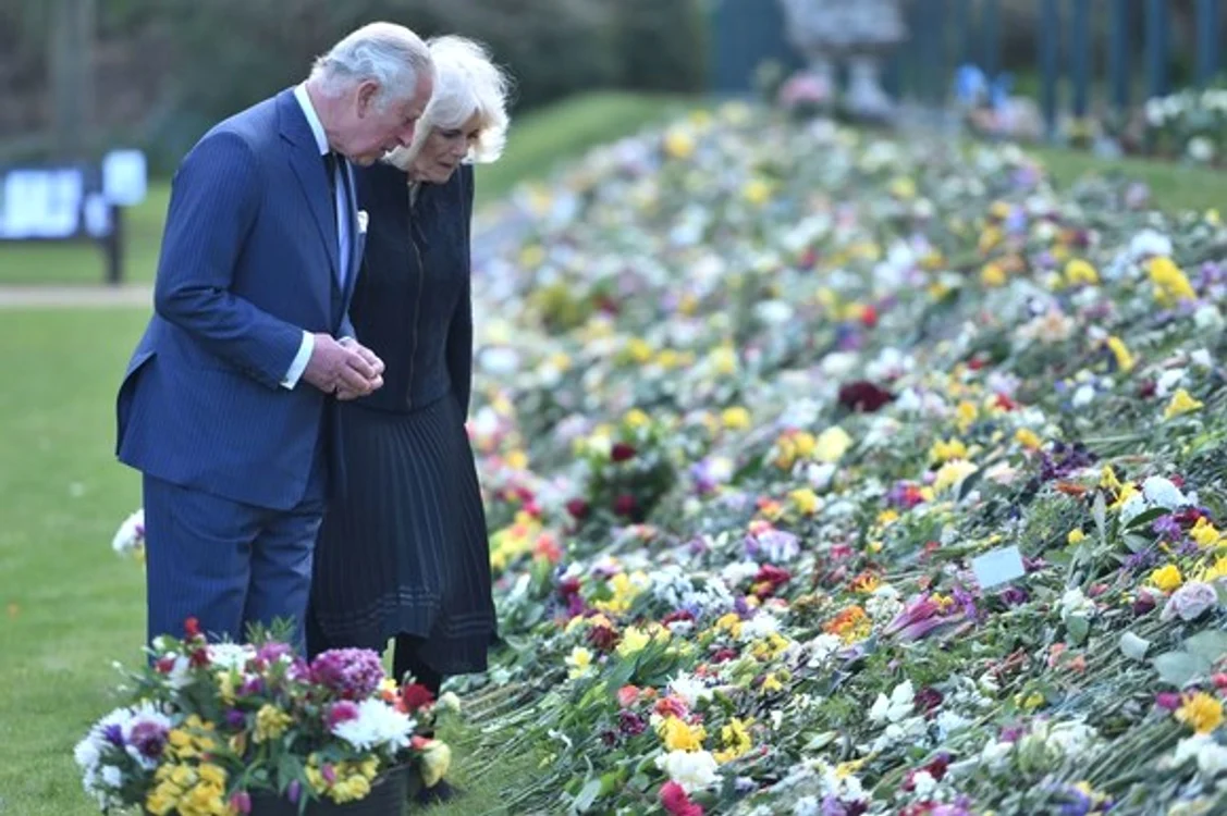 
    Prințul Charles alături de soția sa Camilla, în fața „altarului” cu flori depuse de cetățenii britanici la porțile castelului WindsorSursa foto: Getty Image  