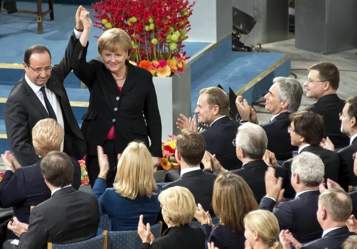 Cancelarul german Angela Merkel şi preşedintele francez Francois Hollande în timpul ceremoniei de decernare a premiului