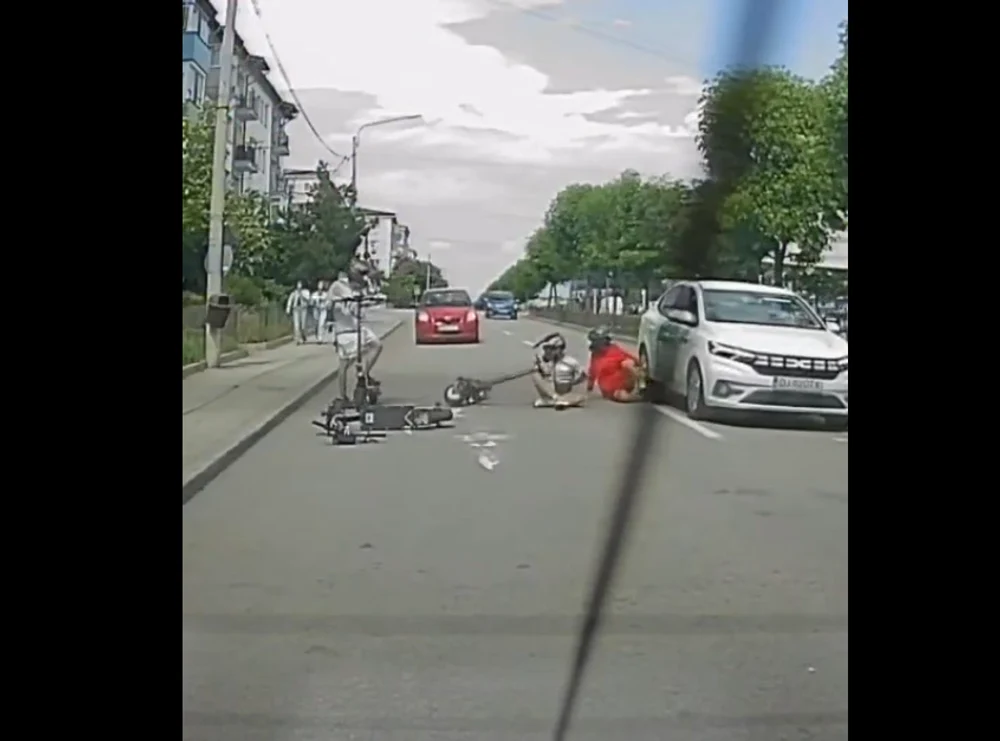 Momentul periculos în care doi copii se prăbușesc cu trotinetele electrice printre mașini. Unul ajunge lângă roțile unui autoturism