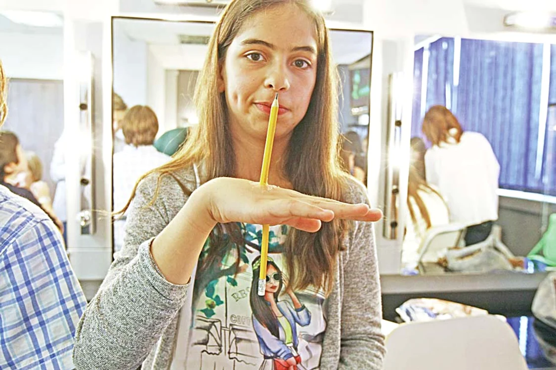 
    Creionul a fost  lipit perfect de  mâna fetiţei  
