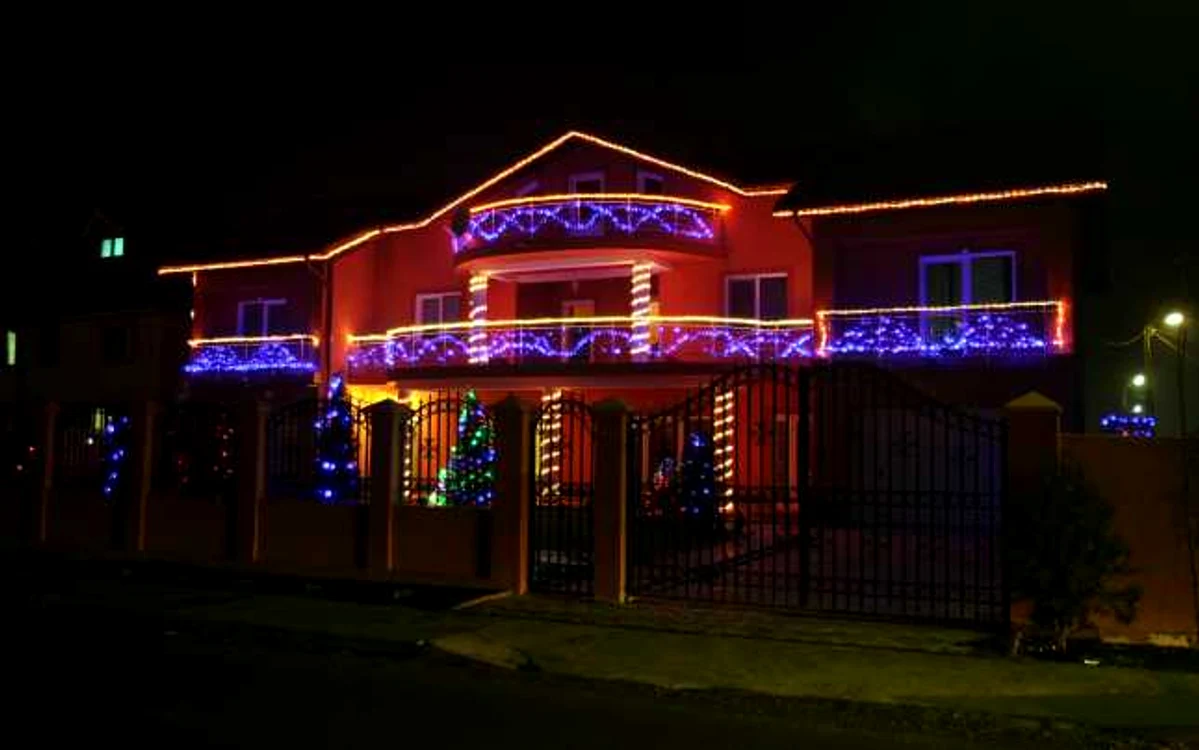  Instalaţia simetrică a casei este în contrast cu luminiţele multicolore care împodobesc brazii