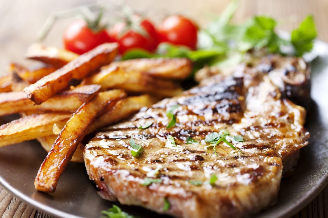 12614754   juicy grilled pork chop  neck cut  with greens jpeg