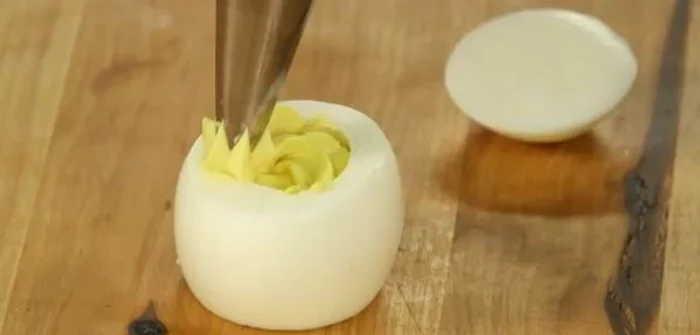 
    Taie ambele capete ale unui ou fiert şi creează un aperitiv pe care copiii îl vor îndrăgi!Foto: Captura Youtube  