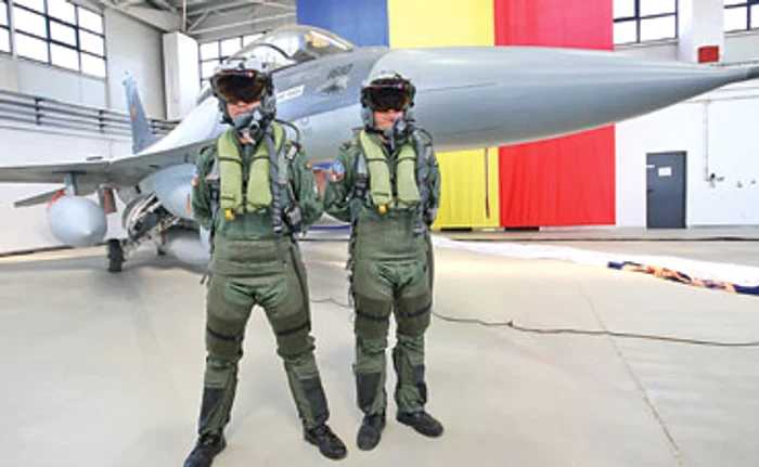 Lt. comandor Vlad Creţu (stânga) şi căpitan comandor Cătălin Micloş, alături de unul din cele 12 avioane F16