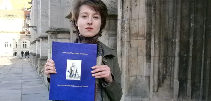 Luciana Tămaş ţinând în mână o culegere de lucrări ştiinţifice semnate de colegii ei şi de ea. foto.facebook