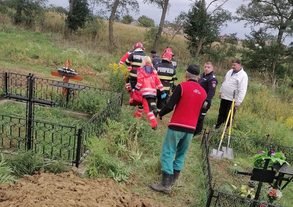 Cine sapă groapa altuia... Un bărbat care lucra la un loc de veci în cimitir a fost prins sub malul de pământ