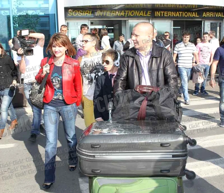 Marina Almăşan şi milionarul Georgică Cornu, însoţiţi de copii, au fost asaltaţi de reporteri la aeroport.