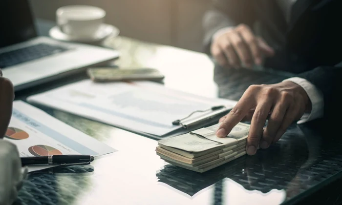 Bărbat care dă mită un tenac de dolari americani FOTO Shutterstock