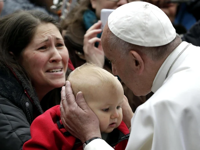 Papa Francisc sărutând un copil în cursul unei vizite în Suedia FOTO EPA