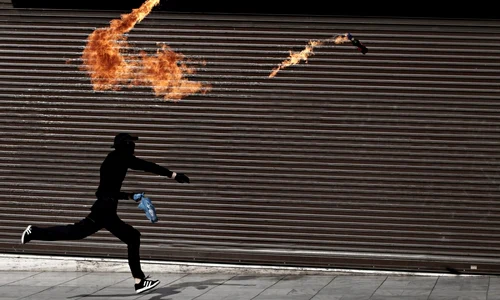 Un manifestant aruncă cocktailuri Molotov către poliţişti în timpul grevei de 24 de ore în Atena Grecia FOTO Mediafax/Hepta