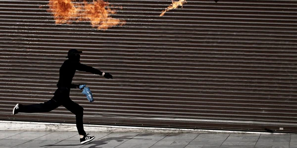 Un manifestant aruncă cocktailuri Molotov către poliţişti în timpul grevei de 24 de ore în Atena Grecia FOTO Mediafax/Hepta