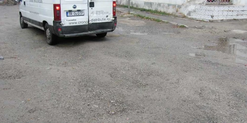 Parcarea plină de gropi din zona pieţei Peco