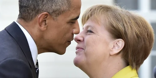 Preşedintele american şi cancelarul german Angela Merkel se sărută la sosirea lui Obama la Palatul Herrenhausen din Hanovra Germania unde se întâlnesc pentru discuţii bilaterale FOTO AFP