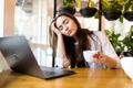 portrait tired young businesswoman sitting table with laptop computer while holding cup coffee sleeping cafe jpg
