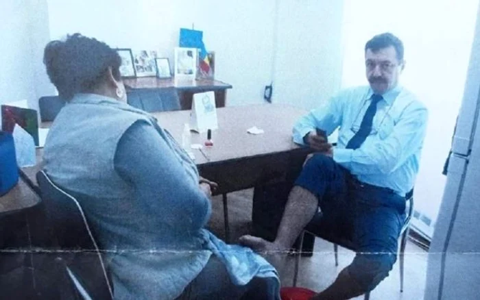 Directorul Marian Rotaru în timp ce femeia de serviciu îi îngrijeşte picioarelefoto: scandaldegorj.ro