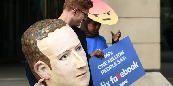 Protestatari care poartă o mască cu chipul directorului Facebook Mark Zuckerberg şi un emoji supărat demonstrează în faţa Casei Portcullis din Londra Marea Britanie FOTO EPA EFE Facundo Arrizabalaga