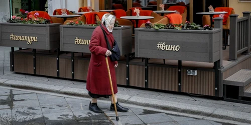 O bătrână trece prin faţa unui restaurant gol din Moscova FOTO EPA-EFE