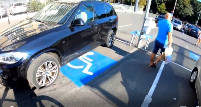 Imagine cu BMW-ul parcat pe un loc destinat persoanelor cu dizabilități.